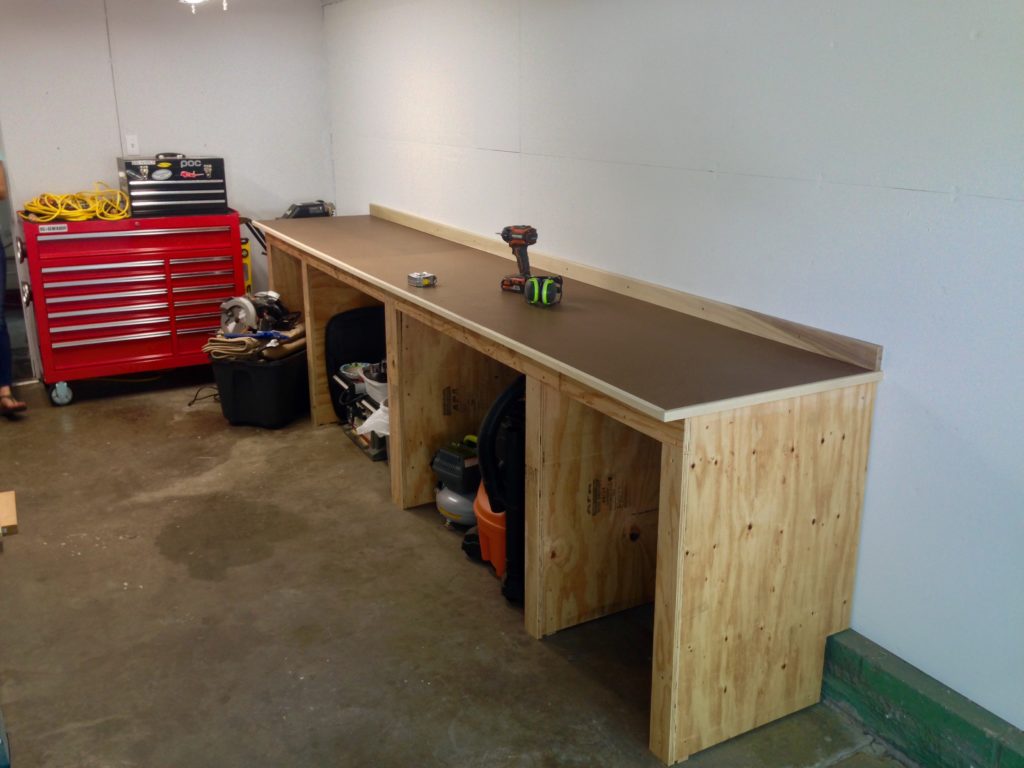 Almost there! Masonite top screwed to the plywood top so that it can be replaced as needed. Trimmed out the perimeter and "backsplash" with poplar. Eased the edges of the poplar with a router.